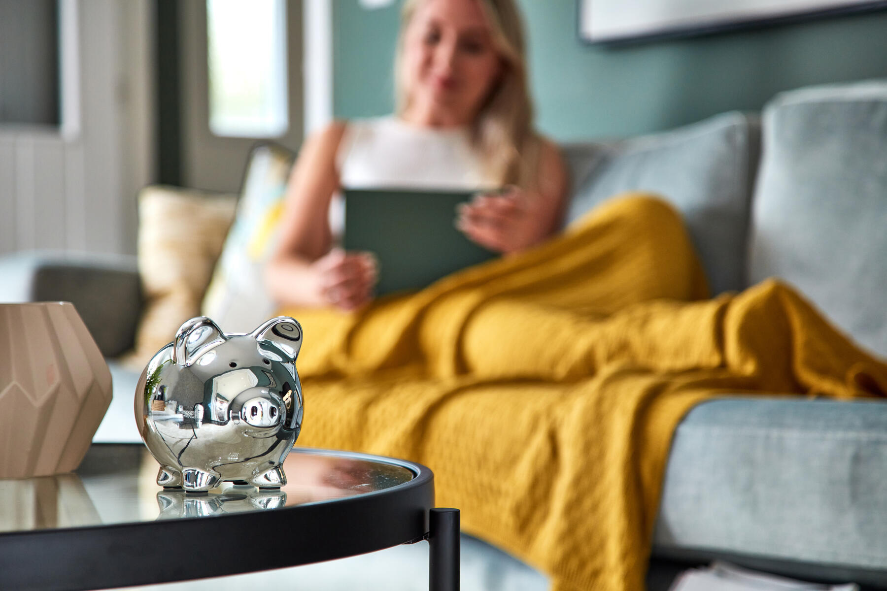 Lady on sofa with piggy bank